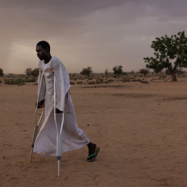 A man walks using crutches in a refugee camp